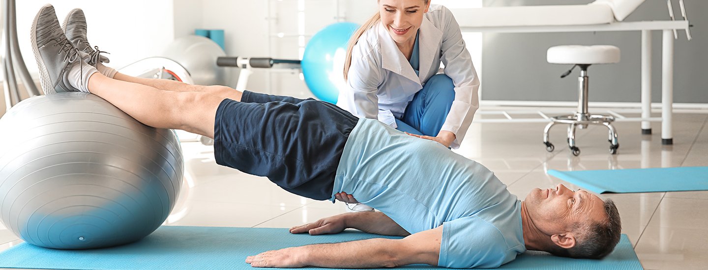 man on floor exercising with physical therapist